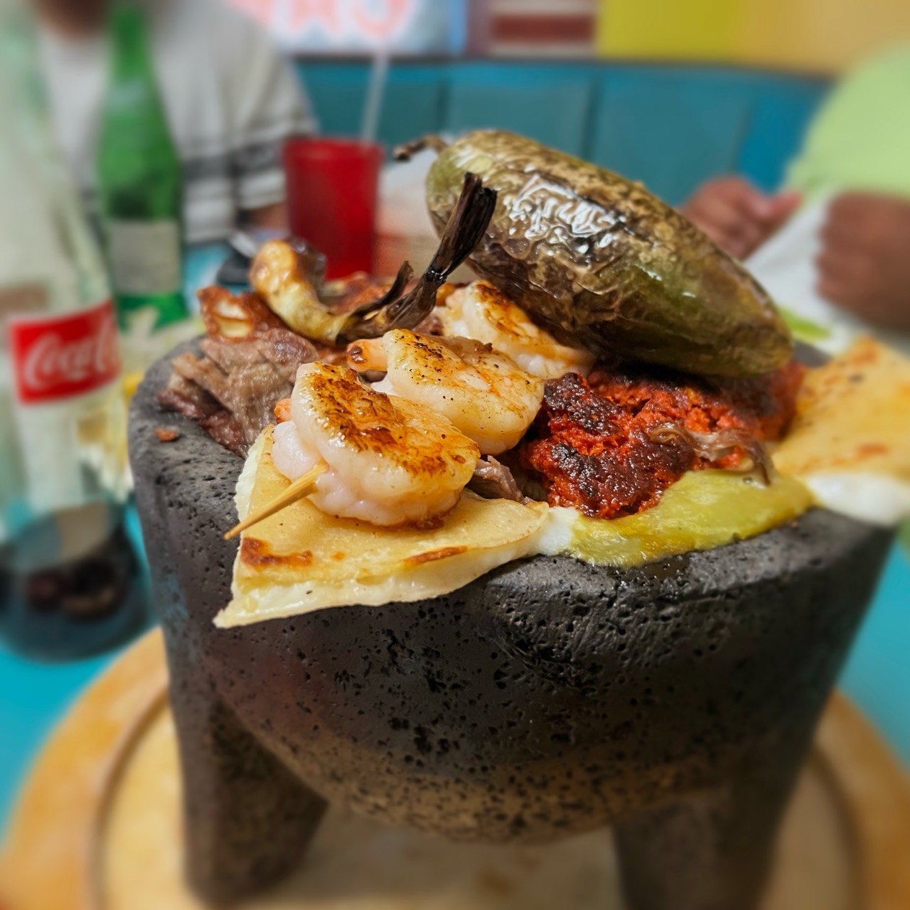 A post-hike platter holds grilled shrimp, meat, cheese, and a roasted pepper.