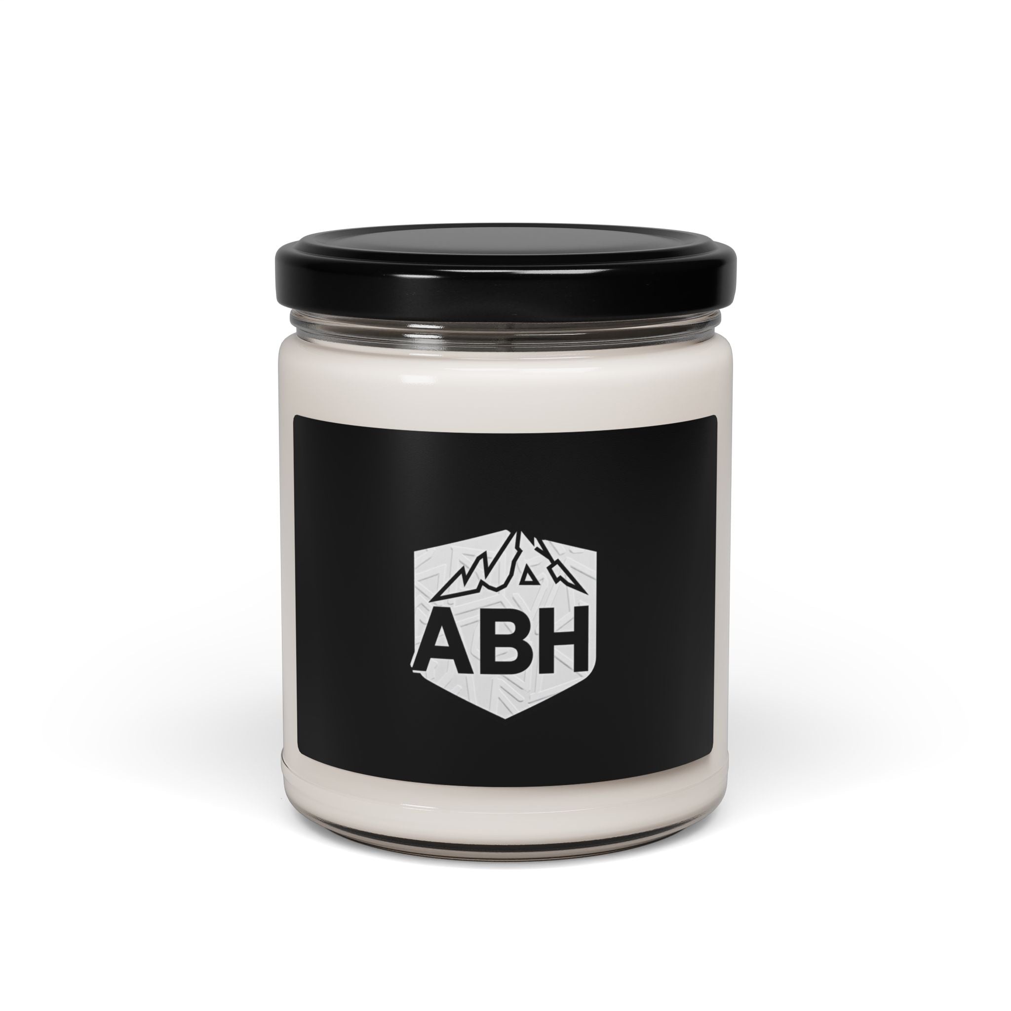 White candle in a clear glass jar with a black lid and black ABH mountain-logo label